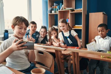 Arkadaş canlısı sınıf arkadaşları selfie çekmeye çalışıyor.