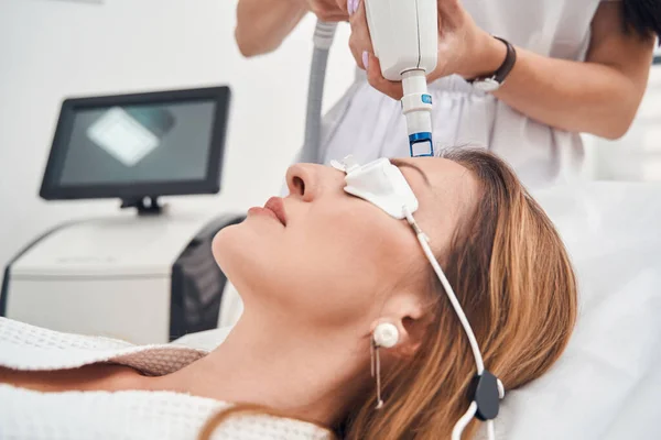 Senhora atraente relaxante durante o procedimento de reguvenation na clínica — Fotografia de Stock