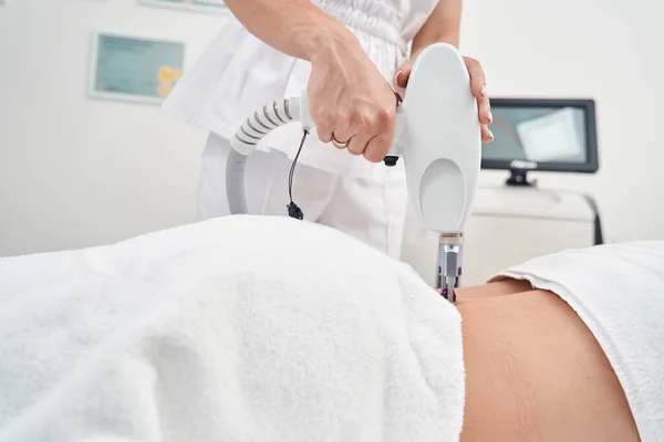 Beauty professional treating woman with laser equipment — Stock Photo, Image