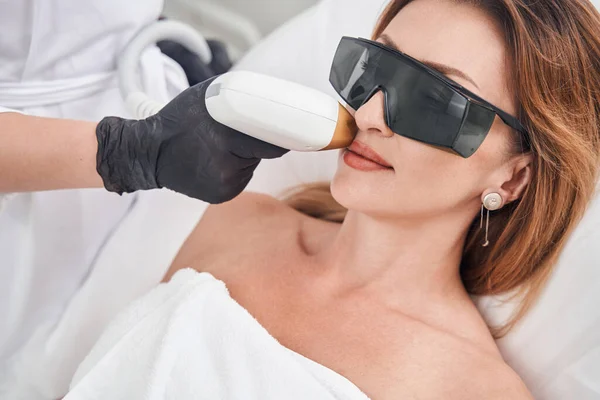 Entspannte hübsche Frau bei Gesichtslaser-Epilation — Stockfoto