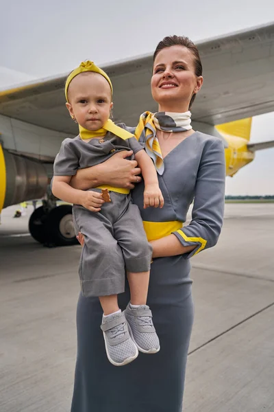 Joyous flight attendant and her daughter at the airport — Stock Photo, Image