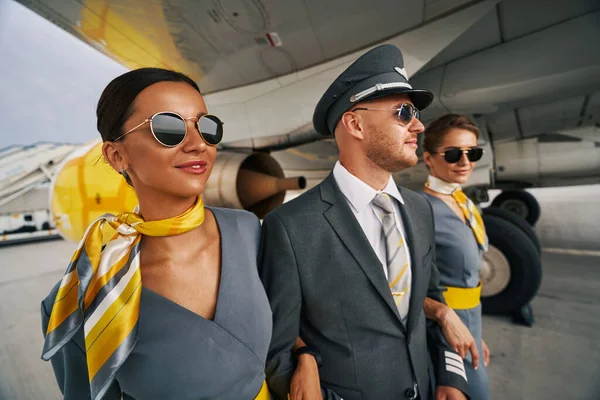 Letec ve slunečních brýlích a letušky ženského pohlaví pokračují — Stock fotografie