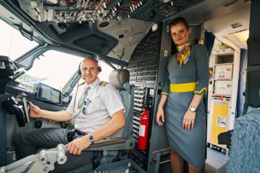 Memnun pilot ve kameraya poz veren sevimli bir hostes.