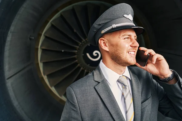 Joyful schattig piloot met een telefoongesprek buiten — Stockfoto