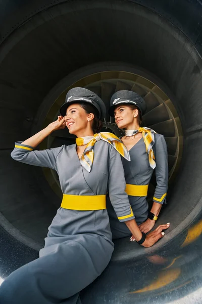 Two lovely stewardesses sitting inside the aeroengine — Stock Photo, Image