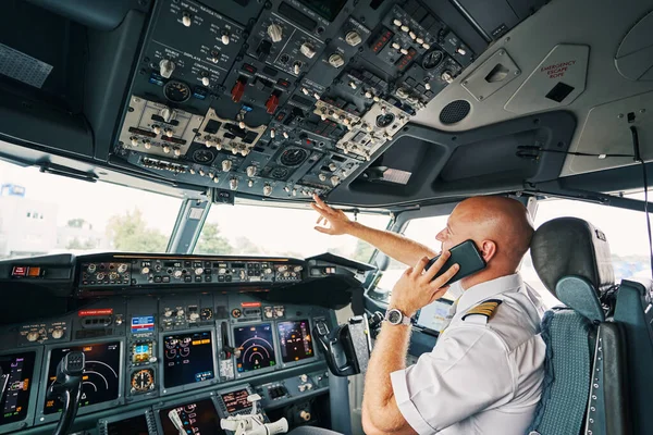 Airline captain flipping the switch on the overhead control panel — Stock Photo, Image