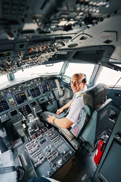 Pleased young pilot sitting in the cockpit before the take-off — Stock Photo, Image