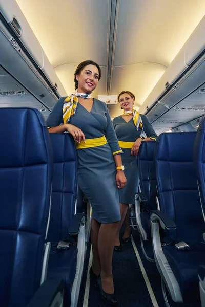 Stylish flight attendants posing for the camera before the take-off — Stock Photo, Image