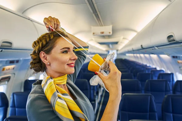 Stewardess using a breathing apparatus during a pre-flight safety demonstration