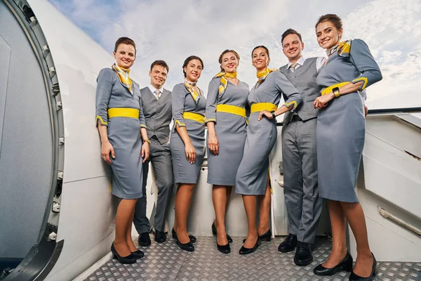 Seven flight attendants standing on the boarding stairs — Stock Photo, Image