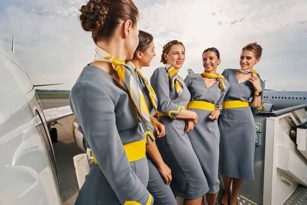 Group of five stewardesses having a conversation outside — Stock Photo, Image