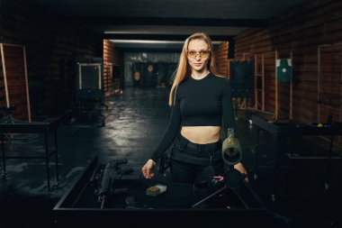 Atış poligonunda koruyucu gözlüklü sakin bir kadın.