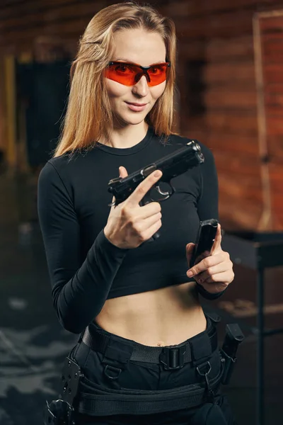 Mujer en gafas protectoras sosteniendo una pistola —  Fotos de Stock