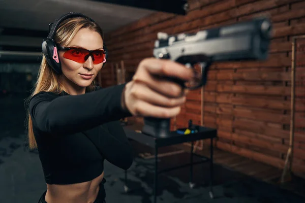 Zkušená střelkyně míří pistolí na cíl — Stock fotografie