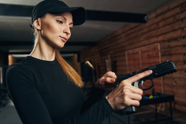 Sereno experimentado tirador femenino amartillando su arma —  Fotos de Stock