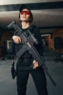 Önüne bakan ateşli bir silahı olan hoş bir genç nişancı.