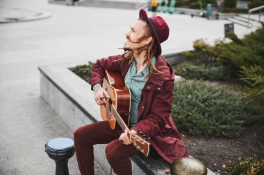 Rahat genç müzisyen hoş enstrümantal bir melodi yaratıyor.