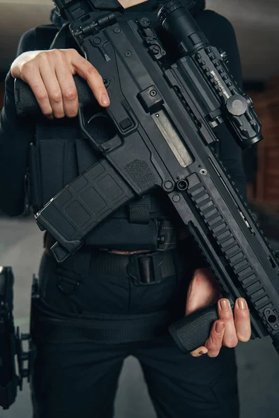 Tirador femenino caucásico con un arma de fuego de pie en el interior —  Fotos de Stock