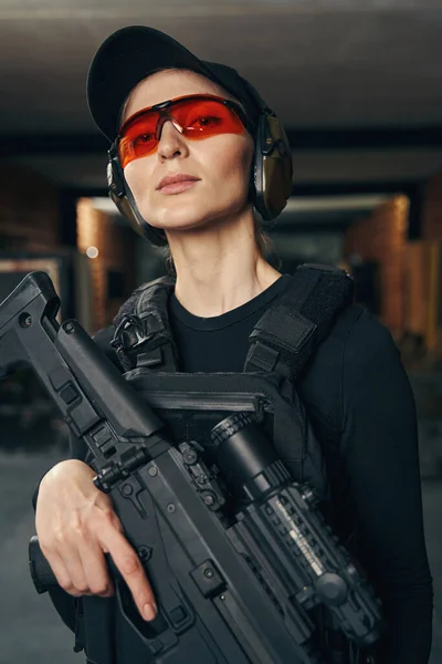 Mujer atractiva con un arma de fuego posando para la cámara —  Fotos de Stock