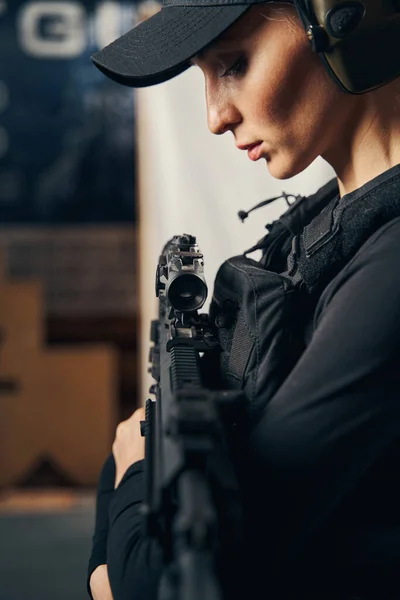 Atractivo tirador femenino presionando el rifle de asalto para sí misma —  Fotos de Stock