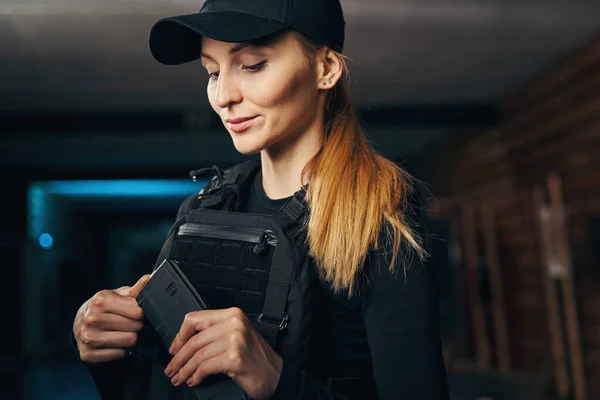 Linda dama en un chaleco antibalas cargando su arma —  Fotos de Stock