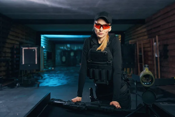 Calm female sniper in a bulletproof vest looking ahead — Stock Photo, Image