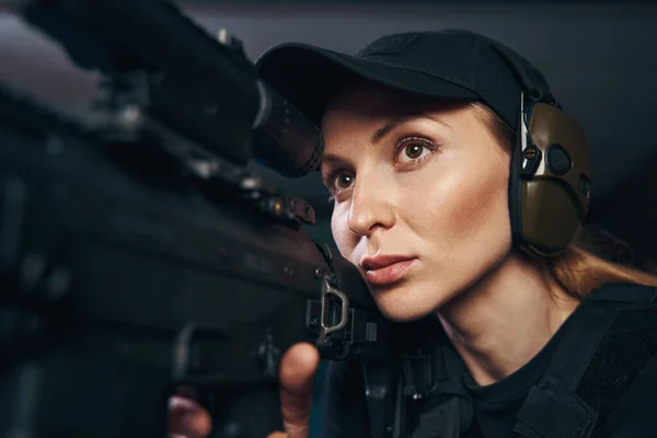 Hermosa dama concentrada disparando un rifle de asalto —  Fotos de Stock