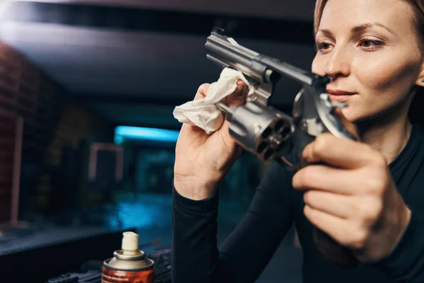 Erfahrene kaukasische Scharfschützin putzt ihren Revolver — Stockfoto