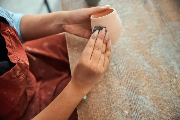 Potier femelle mains ponçage pot d'argile dans l'atelier — Photo