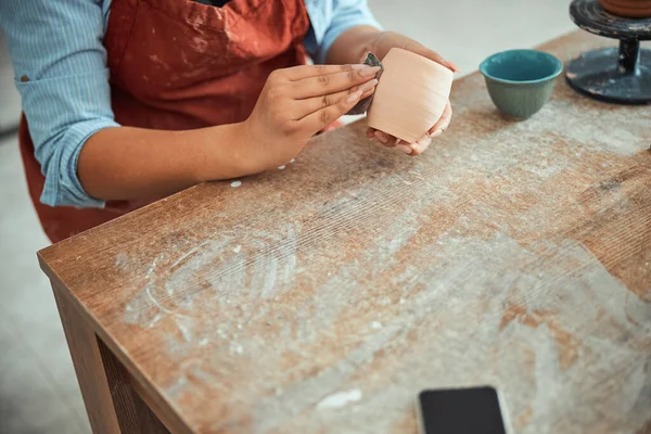 Жіночий кераміст руки шліфування глиняного горщика в керамічній майстерні — стокове фото