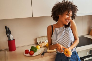 Mutlu genç aşçı cep telefonuyla konuşuyor.