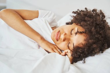 Güzel, barışçıl, siyah saçlı kadın sabahları uyukluyor.