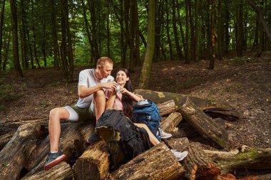 Ormanda atıştırmalık yiyen neşeli genç çift.