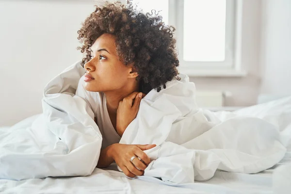 目覚め後にベッドに寝そべっている魅力的な女性 — ストック写真