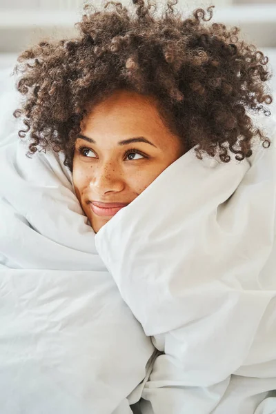 Gelukkig mooi krullend hoofd dame dagdromen in haar bed — Stockfoto