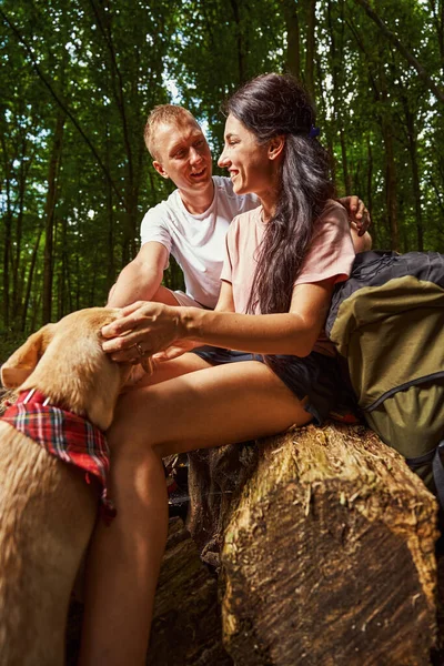 Felice giovane coppia con cane godendo di aria fresca della foresta — Foto Stock