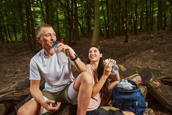 Allegro giovane coppia che alimenta la fame durante la passeggiata nella natura — Foto Stock