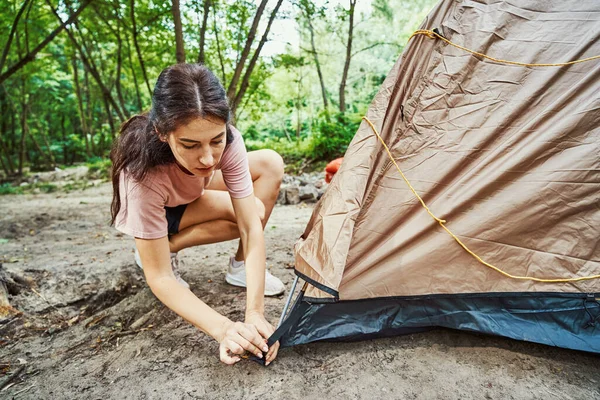 Giovane donna attiva che fissa tenda in legno — Foto Stock
