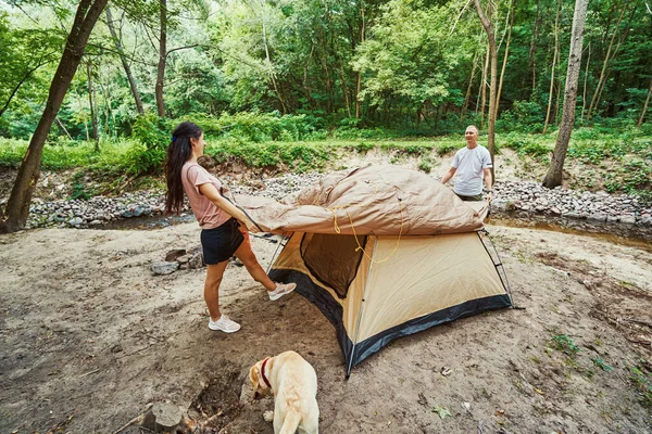 Felice coppia attiva preparare tenda per le vacanze nella natura — Foto Stock