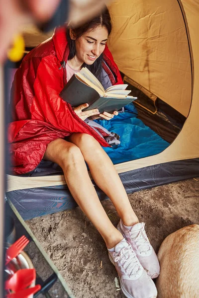 Felice giovane femmina godendo la lettura in tenda — Foto Stock