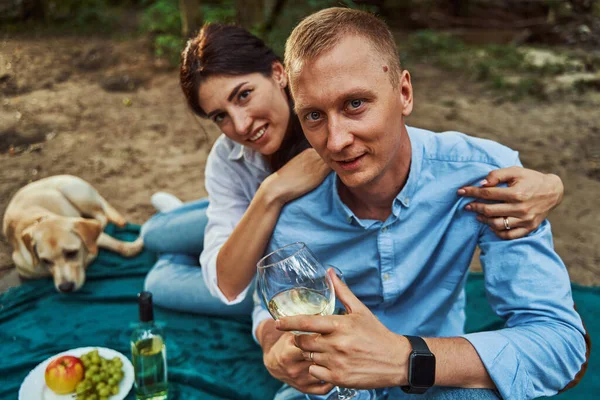 Pareja feliz teniendo cita en el bosque con el perro — Foto de Stock