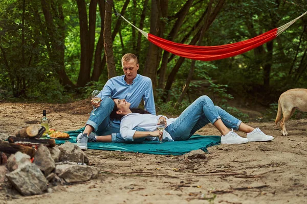 Amando pareja joven disfrutando de picnic en madera —  Fotos de Stock