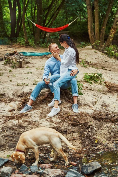 Jóvenes amantes de picnic con perro en la naturaleza —  Fotos de Stock