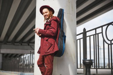 Rastalı adam kameraya bakıyor.