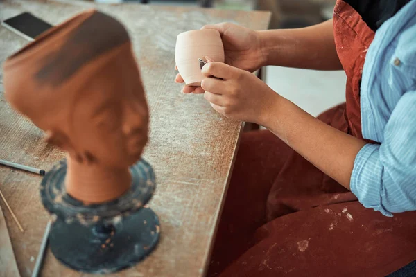 Femme potier mains ponçage céramique dans l'atelier de poterie — Photo