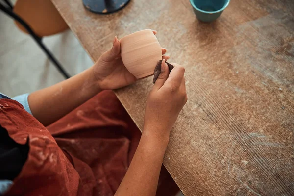 Artisanat mains pot d'argile de polissage dans l'atelier de poterie — Photo