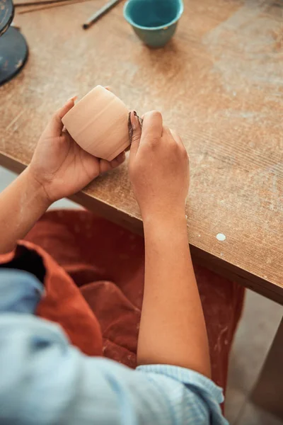 Potier femme polissage pot d'argile en atelier de poterie — Photo