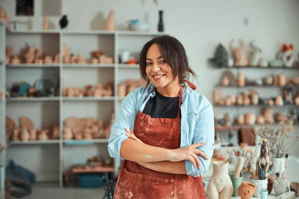 Ceramista feminina alegre em pé na oficina de cerâmica — Fotografia de Stock