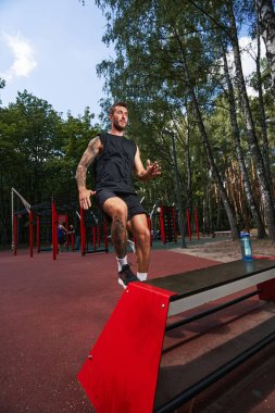 Genç güçlü adam dışarıda kardiyo çalışması yapıyor.