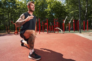 Motive olmuş atletik erkek dışarıda kardiyo eğitimi alıyor.